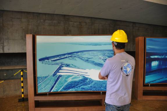 Observando fotos da Usina de Itaipu, em Foz do Iguaçu, fronteira de Brasil e Paraguai